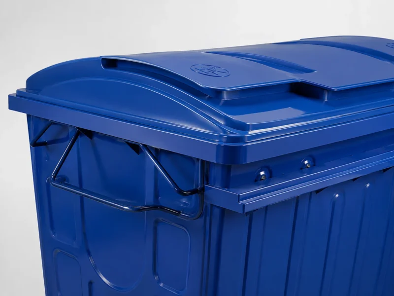 Blue Metal Waste Container Segmented Lid and Side Handle Detail Close-up of segmented lid and side handling bar on a blue metal waste container