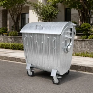 Metal four-wheel waste container with curved lid in a residential street area