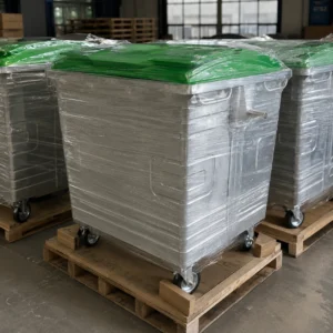 1100L Galvanized Steel Waste Container Export Packaging | KOVANTO 1100L galvanized steel waste containers with green plastic lids wrapped and secured on wooden pallets for export