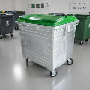 1100L Galvanized Steel Waste Container Showroom Display | KOVANTO 1100L galvanized steel waste container with green plastic lid displayed in a waste bin showroom