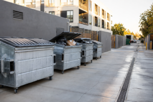 Galvanized waste containers at a commercial collection service lane